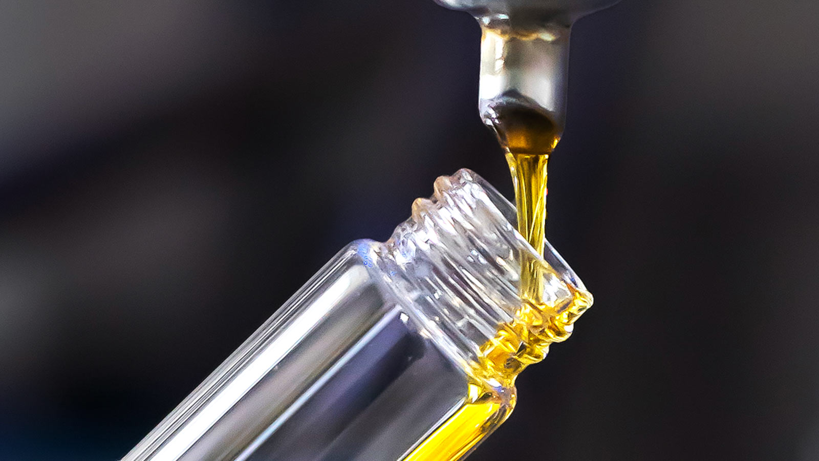 Closeup of vapor extracted cannabis concentrate being poured into tube
